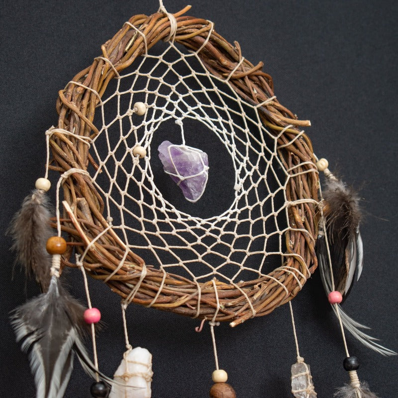 Crystal Details: Close-up of raw crystals on a handmade dreamcatcher, highlighting their natural textures and healing properties.