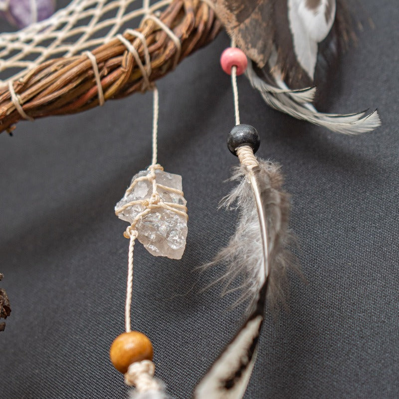 White dreamcatcher adorned with natural crystals, eco-friendly materials, and intricate handmade details. Perfect for boho decor.