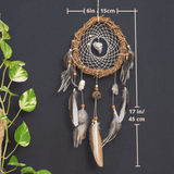 Full Dreamcatcher Display: Handmade white dreamcatcher with natural crystals, semi-precious stones, and feathers, hanging on a wall as boho decor.