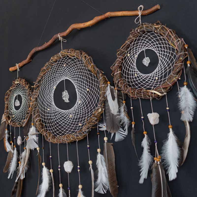 Three handmade dreamcatchers with quartz hanging on the wall